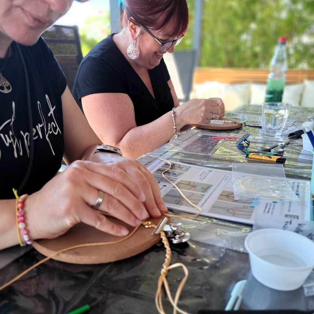Auf Schmuckworkshop Event, der am 2026_06_13 stattgefunden hat, fotografiert. Das Makramee Armband wird geknüpft. 